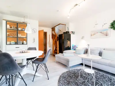 Wohnzimmer mit Couch, Fernseher und Sitzecke