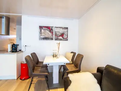 Beach House 21 – Heller Essplatz mit Kunst an der Wand und Blick zur Kochinsel.