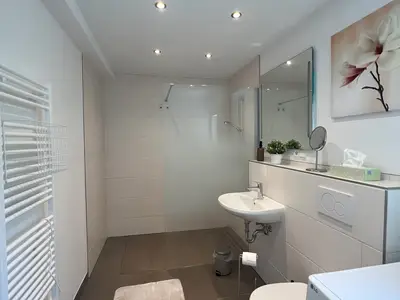 Badezimmer mit großer Dusche und Handtuchtrockner