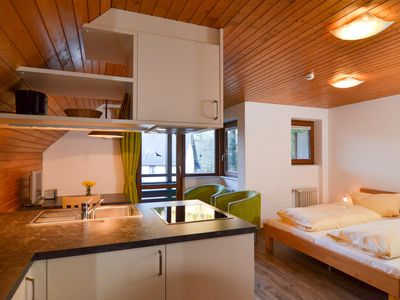 Wohnraum mit Doppelbett und Küchenzeile