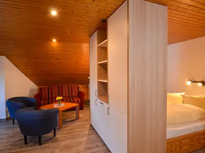 Wohnraum mit abgetrenntem Doppelbett und Küchenzeile