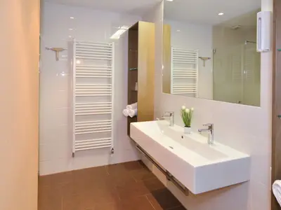 Badezimmer mit Dusche und Doppelwaschbecken