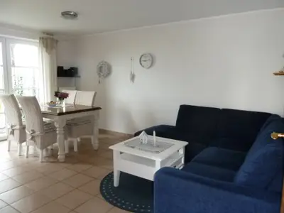 Wohnzimmer mit Eckcouch, Fernseher, DVD-Player und kleiner Musikanlage