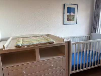 Kinderzimmer mit Wickelkommode, Gitterbett und Etagenbett