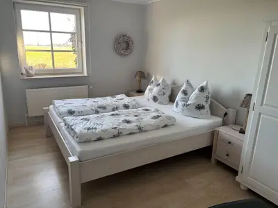 Schlafzimmer mit Doppelbett,  Verdunklungsrollo und Fliegengitter an den Fenstern