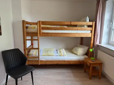 Kinderzimmer mit Etagenbett, Verdunklungsrollo und Fliegengitter an den Fenstern