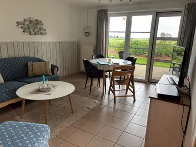 Wohnzimmer mit direktem Zugang zur Südterrasse mit Ausblick in die Natur