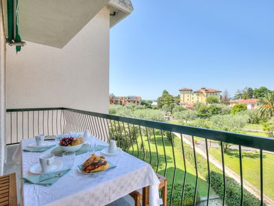 Balkon mit Tisch und Stühlen und Sonnenschirm