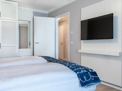 Schlafzimmer mit Flatscreen-TV und Zugang zum Flur