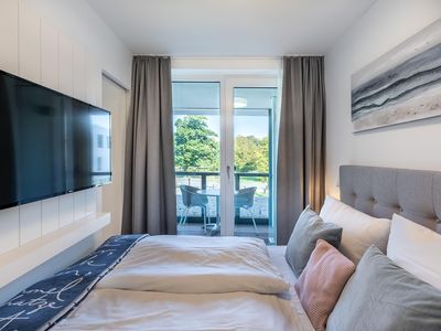 Schlafzimmer mit Flatscreen-TV und Blick zur Loggia
