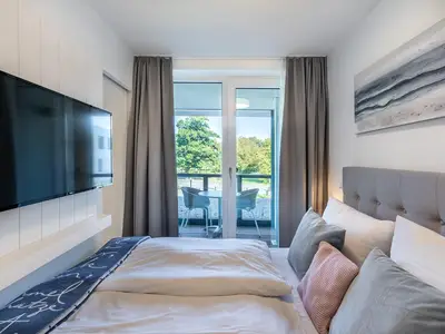 Schlafzimmer mit Flatscreen-TV und Blick zur Loggia
