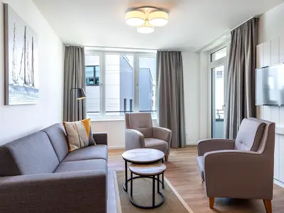 Wohn-Essbereich mit Doppelschlafcouch und Zugang zur Loggia