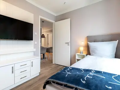 Schlafzimmer "2" mit Boxspringeinzelbett und Flatscreen-TV