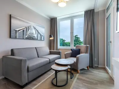 Wohn-Essbereich mit Doppelschlafcouch und Zugang zur Loggia