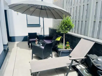 Sonnenterrasse mit Liege und Grill