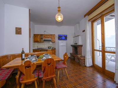 Das Wohnzimmer mit Esstisch, TV und Eingang zum Balkon