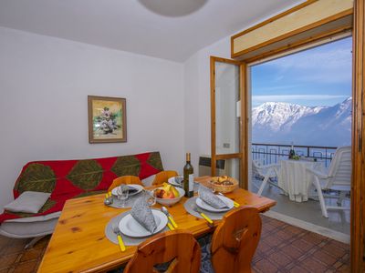 Das Wohnzimmer mit Esstisch und Ausgang zum Balkon