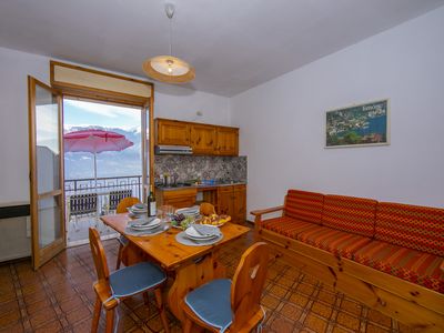 Das Wohnzimmer mit Esstisch und Ausgang zum Balkon