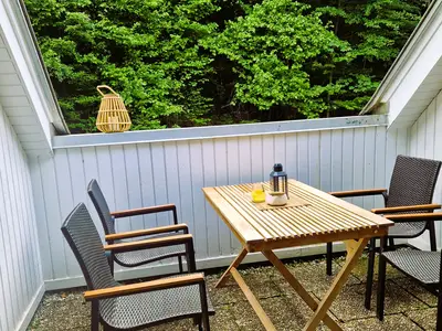 Unterer Balkon am Waldrand mit Tisch und 4 Stühlen