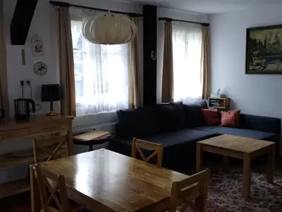 Modernisierter Wohnbereich mit ausziehbarer Couch und Flachbildschirm-Fernseher.