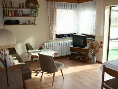 Stube mit Couch, TV, Radio und Durchgang zum Wintergarten
