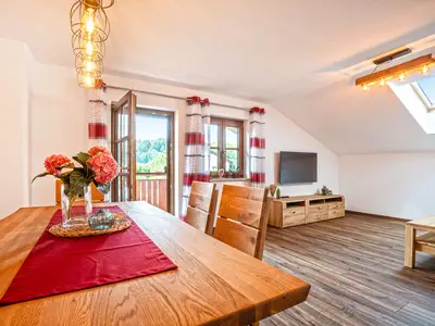 Wohnzimmer mit Flat TV und Esstisch