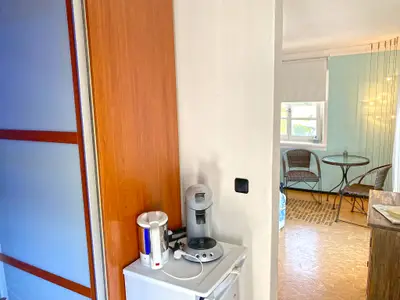Kleiderschrank mit Kühlschrank, Wasserkocher und Kaffeemaschine im Vordergrund