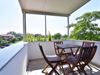 Der Balkon mit Tisch und Stühlen mit Blick auf den Park und die Straße