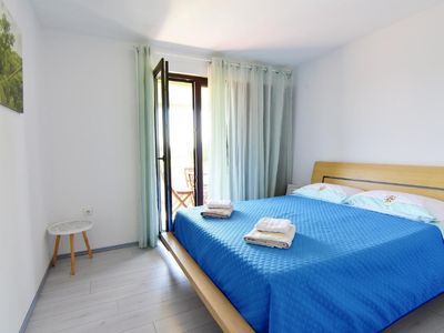 Das Schlafzimmer mit Doppelbett und Ausgang zum Balkon