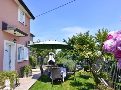 Der mit Blumen geschmückte Garten und die private Terrasse am Eingang