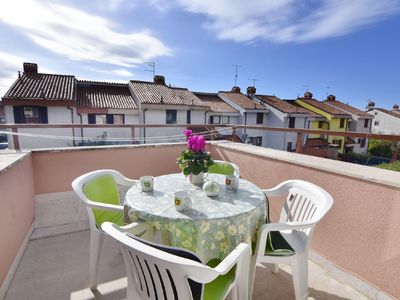 Der sonnige Balkon ist mit Tisch und Stühlen ausgestattet