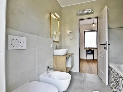 Badezimmer 2 mit Badewanne, Bidet, WC, Fön, Waschbecken und Spiegel