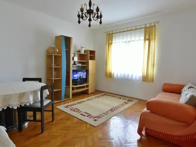 Das Wohnzimmer mit Schlafsofa, Esstisch und Sat-TV