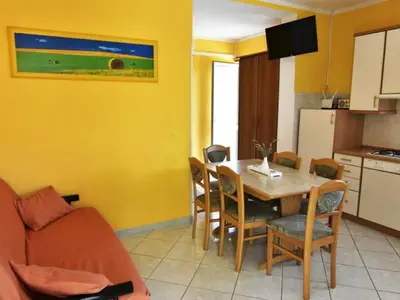 Der Wohnbereich mit Schlafsofa für zwei Personen, Esstisch und Stühlen, ausgestattete Küche