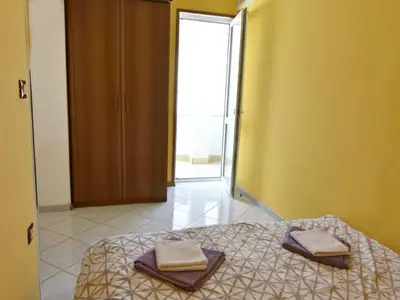 Das Schlafzimmer mit Garderobe und Ausgang zum Balkon