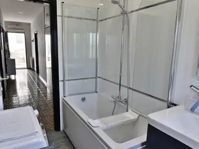 Das Badezimmer mit Badewanne/Dusche, Waschbecken mit Spiegel und Schrank Haartrockner, Bidet, Toilette und Waschmaschine
