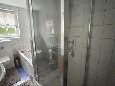 Badezimmer mit Badewanne und Dusche