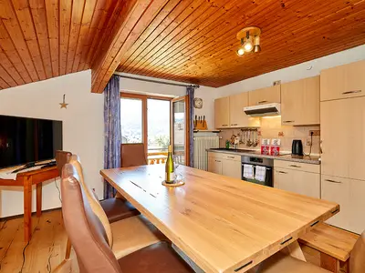 Küche mit großem Esstisch und TV