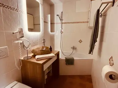 Badezimmer mit Eckbadewann und -Dusche