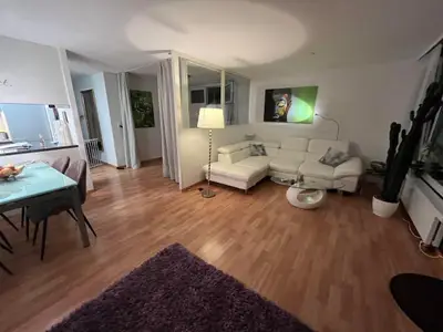 Wohnzimmer mit Sofa, TV und direktem Ausgang zur Terrasse