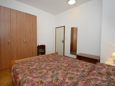 Das Schlafzimmer mit Doppelbett, Kleiderschrank, Stuhl und Spiegel.