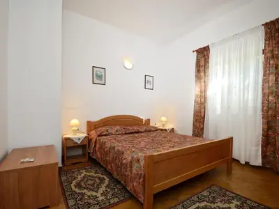 Das Schlafzimmer mit Doppelbett, zwei Nachttische mit Nachttischlampen