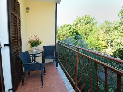 Der an Schlafzimmer 1 angeschlossene Balkon ist mit Tisch und 2 Stühlen ausgestattet und bietet Blick auf den Garten.