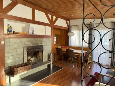 Wohnzimmer mit Esstisch und offenem Kamin