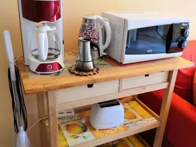 Küche mit Toaster, Kaffeemaschine, Wasserkocher, Mikrowelle und kleinem Staubsauger