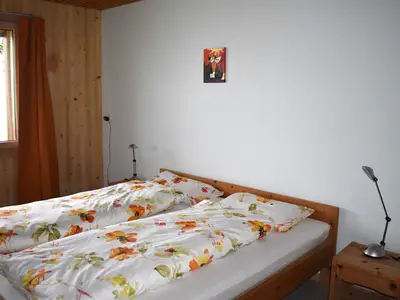 Großes Doppelbett mit Blick auf die Berge. Helle Fenster sorgen für viel Licht und frische Bergluft.