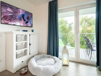 Wohnzimmer mit großem TV und Hundeplatz