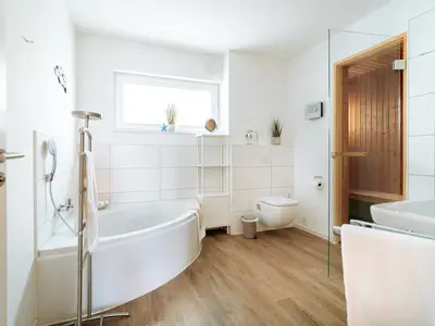 Badezimmer mit Sauna und ebenerdiger Dusche