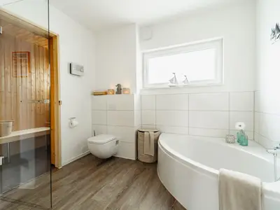 Badezimmer mit Sauna, Wanne und ebenerdiger Dusche