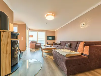 Ferienwohnung Auszeit Wohnzimmer mit Kamin und Sofa